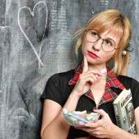 一位年轻编辑在打印出来的双色球走势走势图上用铅笔标注三区比，纸张铺满整张桌面，旁边有计算器